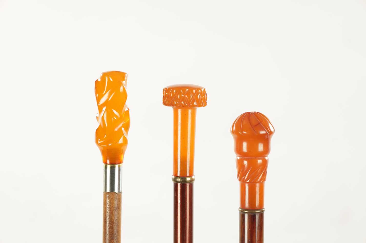 A COLLECTION OF THREE LATE 19TH CENTURY AMBER TYPE TOPPED WALKING STICKS - Image 2 of 3