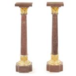 A PAIR OF 20TH CENTURY PORPHYRY TYPE AND ORMOLU MOUNTED COLUMNS