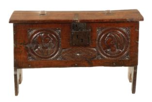 AN IMPORTANT 17TH CENTURY CARVED OAK PLANK COFFER WITH CARVED ROMANESQUE HEADS