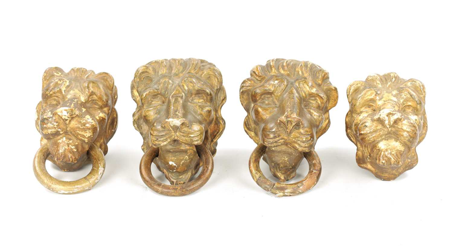 A SET OF FOUR REGENCY CARVED GILTWOOD LION'S HEADS