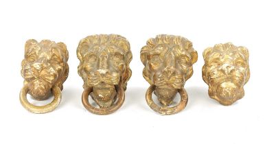 A SET OF FOUR REGENCY CARVED GILTWOOD LION'S HEADS