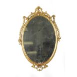 AN 18TH CENTURY CARVED GILTWOOD OVAL HANGING MIRROR