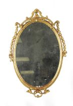 AN 18TH CENTURY CARVED GILTWOOD OVAL HANGING MIRROR