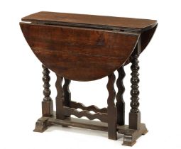 A 17TH CENTURY SMALL OAK GATE LEG TABLE WITH SILHOUETTE LEG