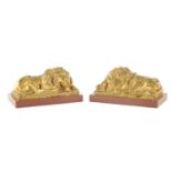 A PAIR OF LATE 19TH CENTURY GILT BRONZE RECUMBENT LIONS