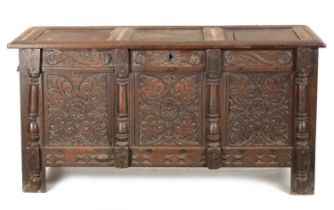 A 17TH CENTURY CARVED OAK THREE PANELLED FRONT COFFER