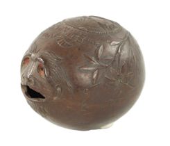 AN EARLY 19TH CENTURY EASTERN CARVED COCONUT BUGBEAR MONEYBOX