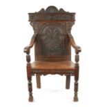 A 17TH CENTURY CARVED OAK WAINSCOT CHAIR