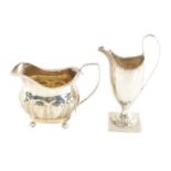 A GEORGE III HELMET CREAM JUG AND MILK JUG