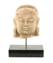 A CARVED STONE HEAD OF AN INDIAN BUDDHA