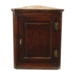 A SMALL 18TH CENTURY PANELLED OAK HANGING CORNER CUPBOARD