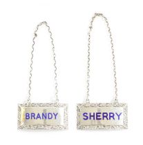 A PAIR OF SILVER AND ENAMEL DECANTER LABELS FOR BRANDY AND SHERRY