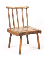 A EARLY 19TH CENTURY ELM AND PITCH PINE PRIMITIVE COMB BACK CHAIR