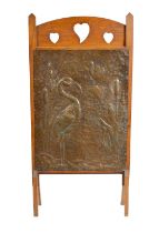 AN ARTS AND CRAFTS PRESSED BRASS AND OAK FIRE SCREEN