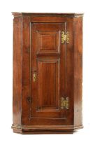 AN EARLY 18TH CENTURY OAK PANELLED HANGING CORNER CUPBOARD