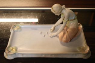 Austrian Porcelain figure of a young woman playing dice on rectangular base with impressed mark to