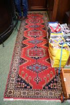 20thC Red Ground Rug Runner with small tassel ends. 300cm in Length