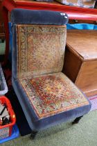 Victorian upholstered low chair with Turned ebonised legs and casters