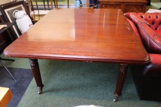 20thC Mahogany Pull out dining table with extra leaf over fluted brass casters