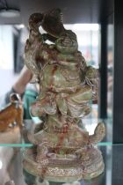 Carved green soapstone figure of a Laughing Buddha on Tortoise with shaped scroll base 24cm in