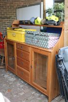 Pine kitchen unit with glazed roors and drawers to centre