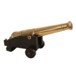 A 19th Century Small Desk Signal Cannon on an oak carriage with two solid wheels, 27cm in Length