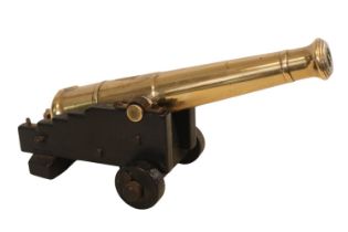 A 19th Century Small Desk Signal Cannon on an oak carriage with two solid wheels, 27cm in Length