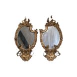 Pair of Gilt Gesso George III Wall mirrors with candle holders, shaped bevelled mirror and foliate