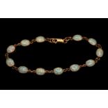 Ladies 9ct Gold Oval Opal set Bracelet. Twelve 9mm Oval Rub over set Opals with Lobster clasp.