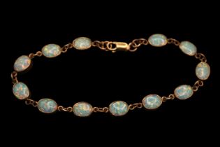 Ladies 9ct Gold Oval Opal set Bracelet. Twelve 9mm Oval Rub over set Opals with Lobster clasp.