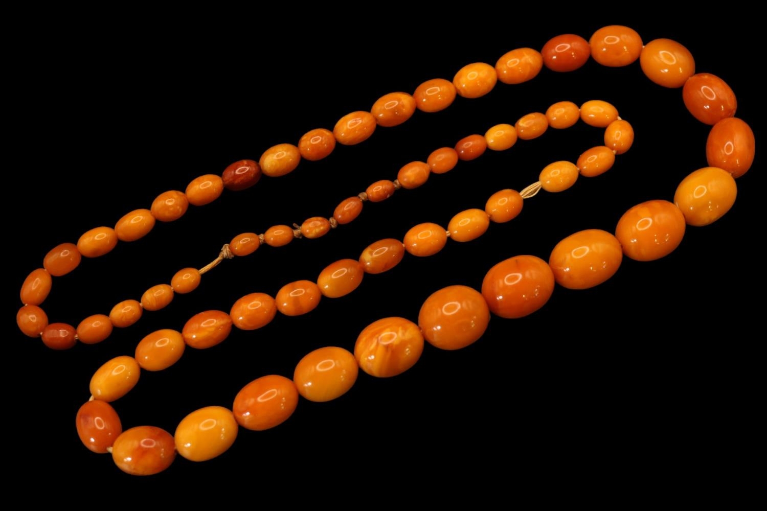 Graduated Amber bead necklace, comprising sixty-one oval butterscotch and honey coloured amber