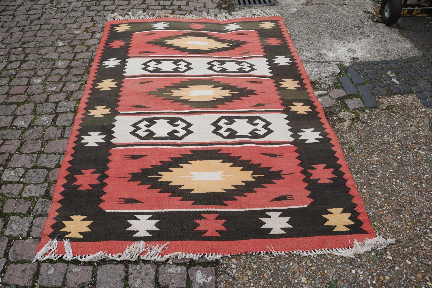 Red ground 20thC Rug with tassel ends 250 x 150cm