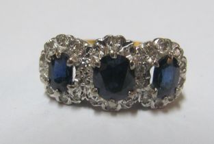 An 18ct three stone sapphire and diamond ring, size M 4.4g