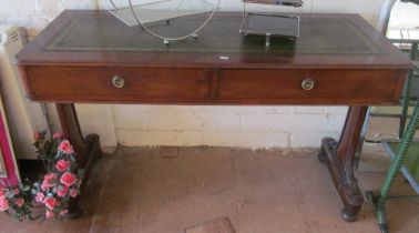 A mahogany two drawer desk on twin end supports with leather inset top