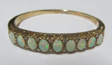 A 9ct gold bangle bracelet set nine opals interspersed with diamonds 56x47mm