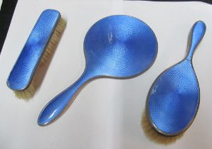 A three piece silver and blue enamel dressing table set (brushes slightly a/f)