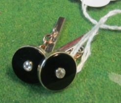 A pair of black onyx and diamond cufflinks