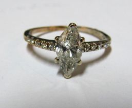 A solitaire lozenge shaped diamond ring with diamond shoulders marked 14kt, size M 108gm, diamond