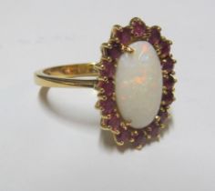 An opal and ruby cluster ring marked 750, size R 8gm