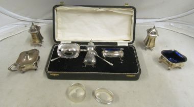 A cased three piece silver condiment set, another and two napkins