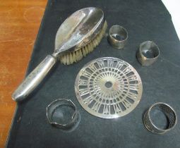 A silver and glass coaster, silver brush, two silver napkins and two Niello napkin rings