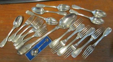 A silver basting spoon and other silver cutlery