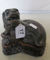 A carved sitting Dog of Fo on carved wooden base