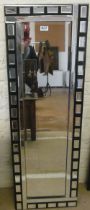 A modern long black and clear glass mirror