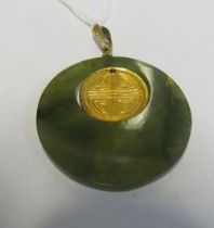 A circular jade pendant with gilt circle of a bird