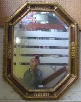 A gilt mirror with burgundy border