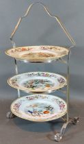 A three tier silver plated cake stand with three plates