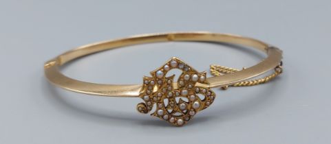 A yellow metal bangle with pearl decoration, 4.5cms by 6cms, 7.7gms