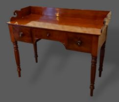 A William IV mahogany washstand, the shaped galleried back above three drawers raised upon turned