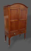 A Regency mahogany cabinet on stand, the arched cornice above two doors, the lower section with a